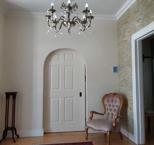  A room adorned with a luxurious chandelier and a chic chair, contributing to a refined and inviting atmosphere.