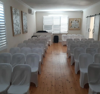A Chapel featuring white chairs arranged neatly against a plain white wall, creating a clean and minimalist atmosphere.