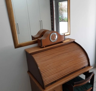  A desk featuring a mirror and a chair positioned in front, creating a functional and stylish workspace.