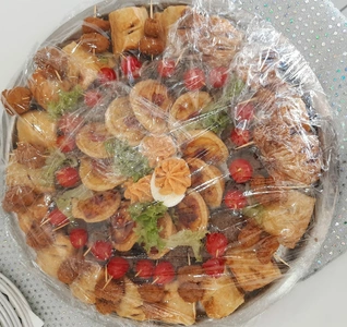 A beautifully arranged platter of food sits on a table, accompanied by an elegant silver tray.